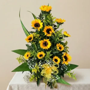 Arreglo floral de 12 girasoles amarillos con lazo decorativo y follaje verde