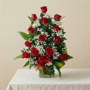 arreglo de doce rosas rojas encima de una mesa