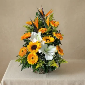 Arreglo primaveral de girasoles, gerberas naranjas y lirios blancos en base rústica de madera en Managua