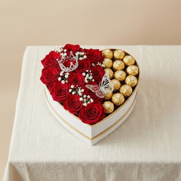 Caja en forma de corazón con rosas rojas decoradas con una corona y bombones dorados con una mariposa