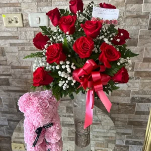 florero de vidrio con rosas y peluche