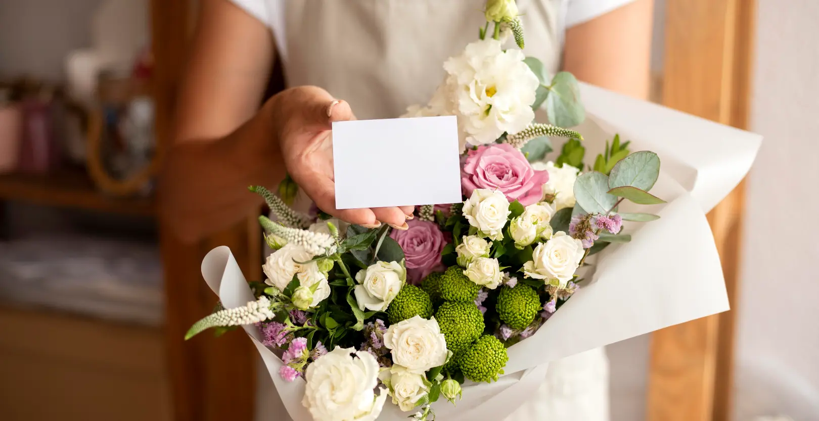 Close up florist holding bouquet and note