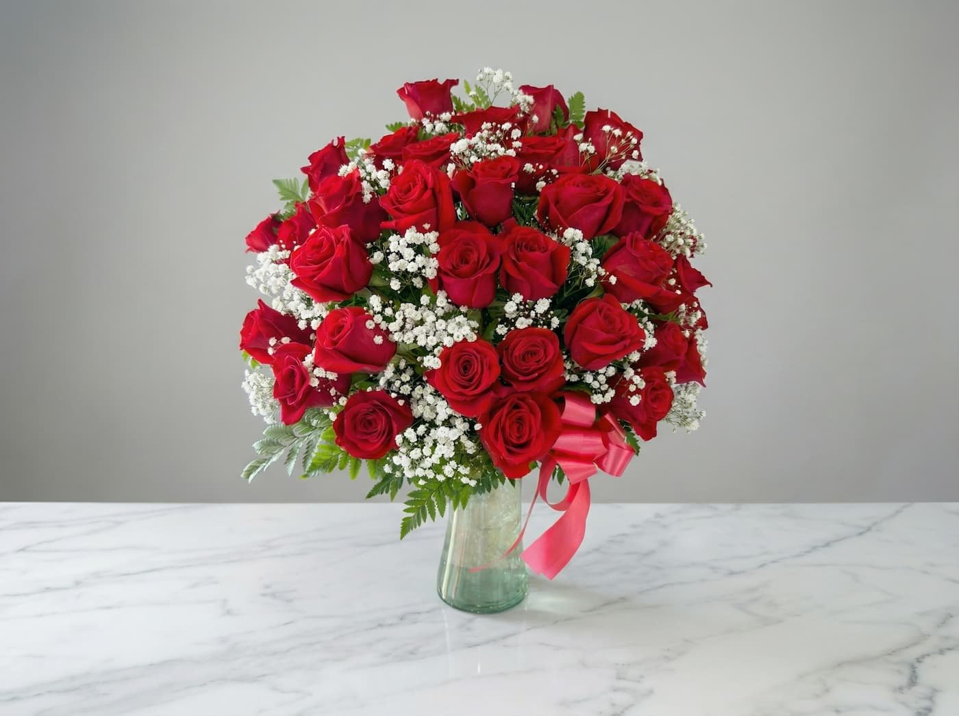 arreglo de rosas rojas en base de vidrio elegante