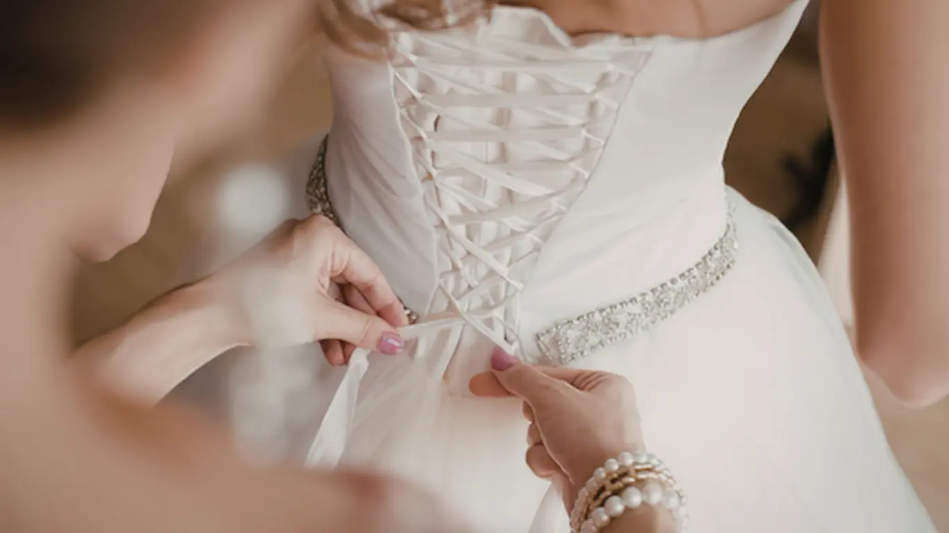 Bride adjusting wedding dress corset